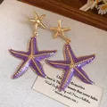 Close-up detail of vintage purple enamel starfish drop earrings on rustic background - Starfish Style (HE32834) / Purple