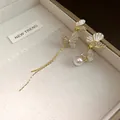 Detalle de pendientes de mariposa asimétricos con perlas y borlas en caja de regalo - Estilo de Mariposa Asimétrica (HE32941) / Dorado