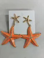 Stylish orange enamel starfish drop earrings featuring a polished gold-tone metal finish. - Starfish Style (HE32834) / Orange