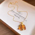 Detailed view of the vintage amber resin elephant pendant with golden trim and eye - Elephant Pendant Necklace / Gold with Coffee