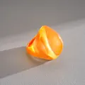 Detailed macro view of an orange statement resin ring with a shimmery pearlescent finish - Fan Shape Style / Orange
