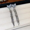 Vue détaillée de boucles d'oreilles à pampilles nœud argenté et zircons - Argent
