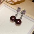 Close-up detail of elegant earrings with brilliant diamonds and dark brown pearls. - Oval Pearl Dangle Earrings (HE33923) / 1 Pair Pack / Silver, Coffee