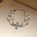 Close-up of a vintage multi-strand pearl bracelet with a heart cross rhinestone pendant - Multi-layer Pearl Bracelet / Silver