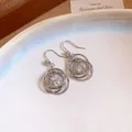 Dettaglio di orecchini circolari color argento con pendente a sfera in zircone brillante - Stile Rotondo Multistrato (HE34320) / Argento