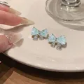 Detailansicht der eleganten minzgrünen Schleifenohrringe mit funkelndem Zirkonia-Besatz - Schleifenstil / Silber