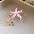 Elegante brazalete vintage dorado con diseño floral de estrella de mar en esmalte rosa - Rosa