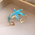 Elegante brazalete dorado con detalles de estrellas de mar en esmalte azul - Azul