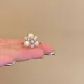 Close-up of a vintage pearl cluster ring with elegant crystal accents worn on a finger - French Retro Pearl Flower Cluster Style (HR3346) / Silver