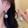 Elegant French vintage pearl earrings with silver flower detail and hammered metal finish. - Wrinkled Flower Drop Pearl Stud Earrings / Silver-White