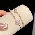Close-up of 18k gold plated double-layer bracelet with shimmering zircon flower charms - Gold