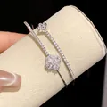 Detail shot of a double-layer bracelet featuring sparkling pavé-set flower motifs. - Silver-White Zirconia