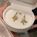Detail of French vintage zircon flower earrings with white enamel in a jewelry box - White Petal / Gold