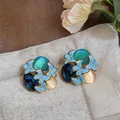 Close-up of elegant forest-style butterfly earrings with cat-eye stones and enamel - Silver Needle / Blue