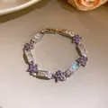 Gros plan d'un bracelet fleuri élégant avec zircons violets et blancs de style coréen. - Rêves Coulants (HB5956) / Violet