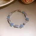 Vue rapprochée d'un bracelet fleur en zircon scintillant avec des pierres bleu clair. - Rêves Coulants (HB5956) / Bleu