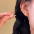 Gros plan de boucles d'oreilles fleur de cerisier en pierre d'œil de chat rose et perle. - Tige de boucle d'oreille en argent - Argent - Rose