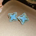 Close-up of vintage light blue star flower stud earrings with an elegant gold trim - Silver Post Style (HE33380) / Blue