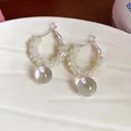 Macro detail of elegant glass bead hoop earrings with a clear glass ball pendant - Silver Needle-Silver-Yellow
