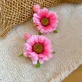 Detail van handgemaakte roze stoffen madeliefjes oorbellen met kleine rozenknop accenten - Tops / Roze