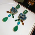 Detail view of retro blue rose earrings with green teardrop pendants and gold accents. - Vintage Rose Flower Drop Style / Silver Earring Post-Green