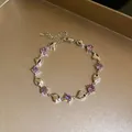 Detailed view of a silver bracelet with purple zircons and heart-shaped charms. - Bracelet (HB6096) / Purple