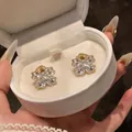 Close-up of 18K gold plated flower clip-on earrings with sparkling cubic zirconia - Clip-On Earrings / Gold