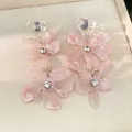 Close-up of pink resin flower earrings with sparkling rhinestones and heart detail. - Pink