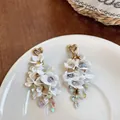 Elegant white fabric flower drop earrings featuring sparkling crystals and heart tassels - White