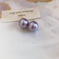 Elegant macro view of 18K gold plated stud earrings featuring round purple pearls. - Round / Diameter 12mm / Purple