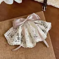 Nahaufnahme des eleganten Haaraccessoires mit weißer Spitze und rosa Satinschleife - Federclips / Weiß-Rosa