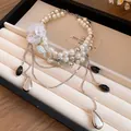 Vue détaillée d'un collier de perles vintage à deux rangs avec fleurs et pompons - Collier-Argent-Blanc