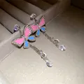 Close-up of butterfly earrings with color-block enamel and sparkling crystal tassels - Earrings (HE33467)