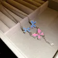 Close-up detail of a sparkling blue and pink butterfly necklace with a crystal tassel drop - Necklace (HN12098)
