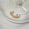Gros plan détaillé d'un élégant clip d'oreille en zircon doré sur une assiette - Style Floral Étincelant (3#) / Pièce Unique / Or