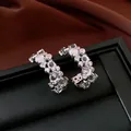 Vista dettagliata di eleganti orecchini a C in argento con accenti in resina e zirconi. - Argento
