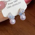 Dettaglio di eleganti orecchini a perla a forma di C con accenti di fiori in cristallo - Orecchini a lobo con perle a forma di C / Argento-Blu