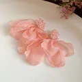 Detailed macro view of elegant pink chiffon flower petal earrings with beaded stud design - Pink