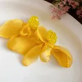 Detailed view of yellow chiffon fabric flower earrings with sparkling beaded centers. - Yellow