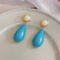 Detailed view of turquoise resin waterdrop earrings with gold-toned round studs - Teardrop Stud Earrings (HE32543) / Blue-White