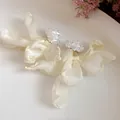 Detailed view of delicate cream chiffon flower stud earrings with crystal clusters - White