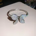Close-up of a sparkling silver butterfly bangle with pavé cubic zirconia details. - Silver