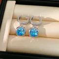Dettaglio ravvicinato di orecchini argentati con zirconi blu brillanti taglio cushion - Orecchini / Blu