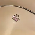 Detailed macro view of sparkling pink heart zircon ear clips with a polished silver finish - Cupid's Arrow Style (7#)