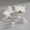 Vista ravvicinata di orecchini a farfalla fatti a mano con perline e luce arcobaleno - Ear Cuff - Argento - Bianco