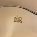Detailed macro shot of an elegant gold butterfly-shaped ring with sparkling cubic zirconia. - Cross Bowknot Style (12#)