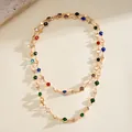 Detailed macro shot of a dopamine-style necklace with colorful crystals and gold discs - Gold-Multicolor