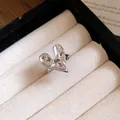 Macro view of a silver heart-shaped ring with unique liquid metal texture in a jewelry box. - Ring / Silver