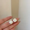 Primo piano di orecchini a lobo quadrati eleganti con motivo floreale e pietra turchese - Stile Fiore in Madreperla a Rombo / Argento
