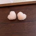 Close-up of elegant peach resin heart stud earrings featuring a sparkling crushed sugar texture. - Silver Needle / Yellow